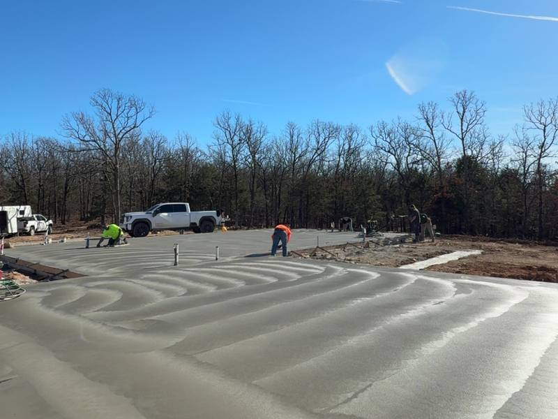 Fresh concrete being screeded and floated on a bright day