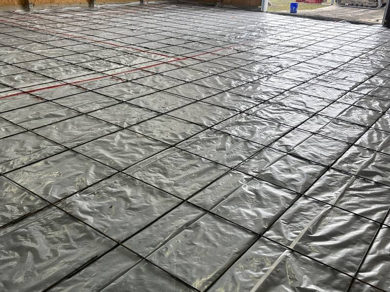 Vapor barrier and rebar grid laid inside a pole barn ahead of the pour
