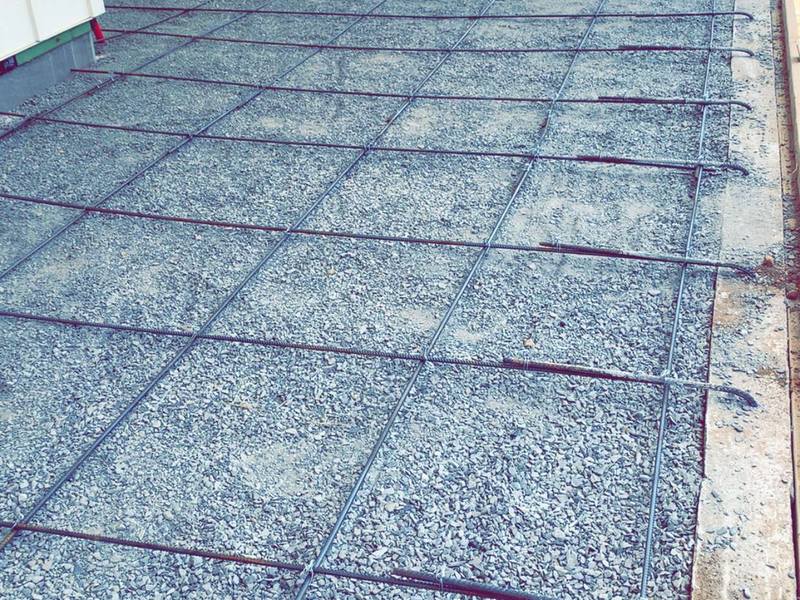 Wire mesh and rebar tied out across a prepared building pad