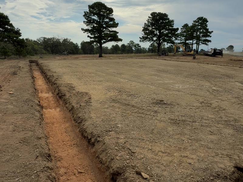 Footing trench excavated across an open field for a new foundation