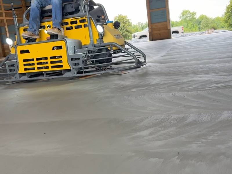 Ride-on power trowel finishing a new shop floor slab